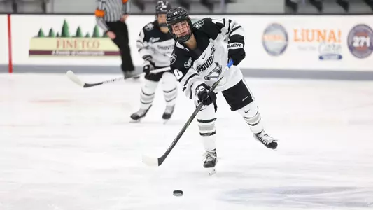 Women's ice hockey player Lauren Mack making a pass during a game