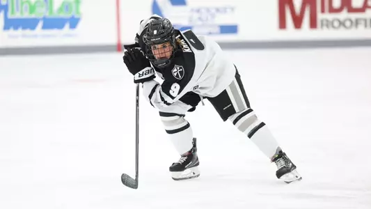 Women's ice hockey player Kiara Kraft skating up ice during a game
