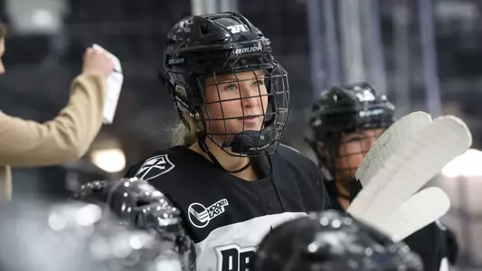 Women's ice hockey player Jessie Pellerin standing on the bench