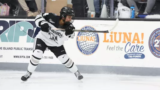Women's ice hockey player Taylor Leemrijse moving the puck up ice during a game
