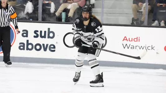 Women's ice hockey player Sami Snyder in front of the net during a game