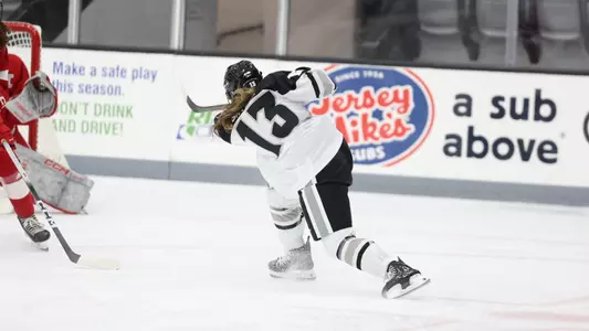 Women's ice hockey player Sami Snyder taking a shot during a game