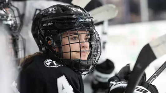 Women's ice hockey player Izzy King on the bench during a game