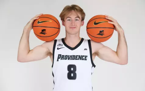 Jack Williams men's basketball player posed shot with basketballs on each shoulder during photo shoot.