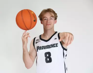 Jack Williams is pictured spinning the basketball with his right hand while his other hand points at the camera during their photoshoot