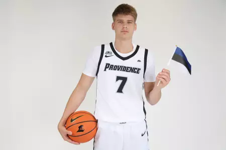 Stefan Vaaks men's Basketball player is pictured holding the Estonia flag in his left hand and a basketball on his hip in his right hand during their photoshoot.