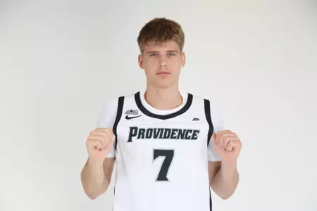 Stefan Vaaks men's Basketball player poses by placing both thumbs under his jersey to show his number during their photoshoot.