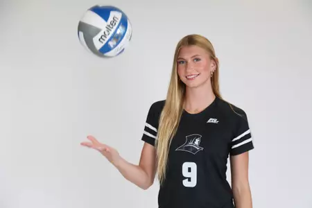 Tori Otter is pictured hitting the ball up in the air with her right hand while she smiles at the camera during team photoshoot for pre-season 2025 photos.