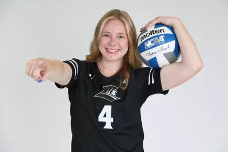 Addy Frye poses with the volleyball in her left arm while she points at the camera with her right arm and smiles during team photoshoot for pre-season 2025 photos.