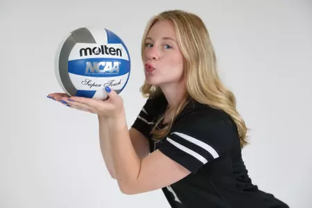 Addy Frye poses by holding the volleyball up with both hands during team photoshoot for pre-season 2025 photos.