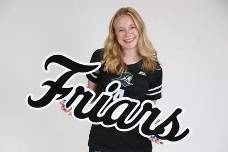 Addy Frye poses with the "Friars" sign and smiles at the camera during team photoshoot for pre-season 2025 photos.