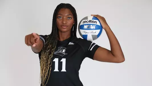 Women's Volleyball player Lyric Berry pointing at the camera with a volleyball in her hand during a preseason media photoshoot in 2025