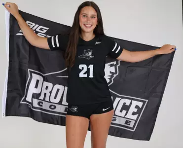 Sophia Adkins poses with the Providence College flag during team photoshoot for pre-season 2025 photos.