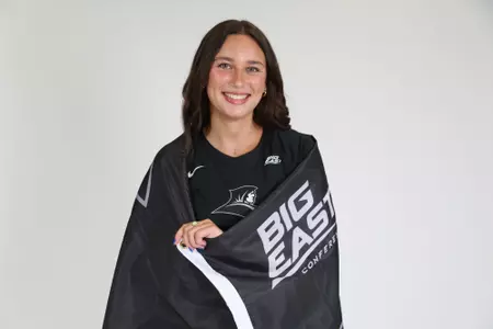 Sophia Adkins poses with the Providence College flag by wrapping it around her during team photoshoot for pre-season 2025 photos.