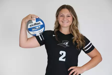 Audrey Kocon is pictured holding the volleyball up in her right arm during team photoshoot for pre-season 2025 photos. 
