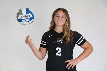 Audrey Kocon poses by throwing up the volleyball with her right hand and with her left hand placed on her hip during team photoshoot for pre-season 2025 photos.