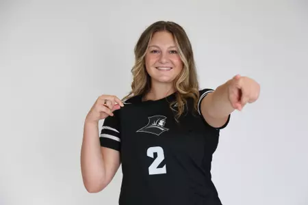 Audrey Kocon poses by pointing her left arm at the camera and pinching the top of her jersey with her right arm during team photoshoot for pre-season 2025 photos.