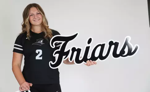 Audrey Kocon is pictured holding up the "Friars" sign while she stands to the right of it during team photoshoot for pre-season 2025 photos.