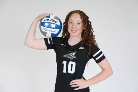 Morgan Martin is pictured holding a volleyball with her right arm while her left arm is placed on her hip and she smiles at the camera during team photoshoot for pre-season 2025 photos.
