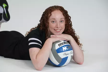 Morgan Martin is pictured resting on the volleyball and smiling at the camera during team photoshoot for pre-season 2025 photos.