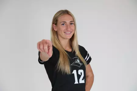 Fielding Mayhugh poses and points at the camera with her right hand and the left placed on her hip while she smiles at the camera during team photoshoot for pre-season 2025 photos.