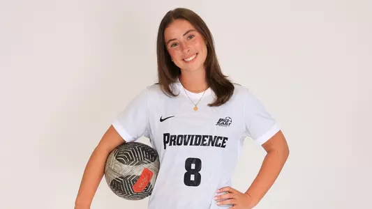 Women's soccer player Colleen Casey poses for a photo with a ball under her arm during a preseason photoshoot in 2025