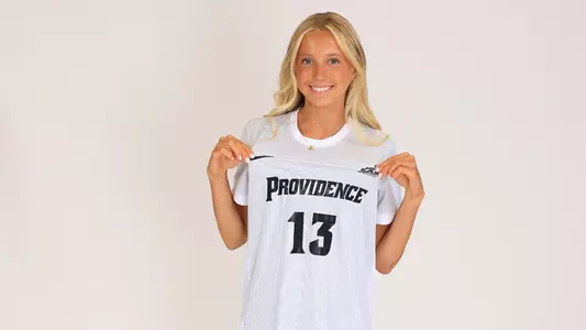Women's soccer player Sophie Tonino poses holding her jersey out during a preseason photoshoot in 2025