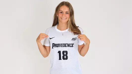 Women's soccer player Eden Wheeler poses for a photo holding her jersey out during a preseason photoshoot in 2025
