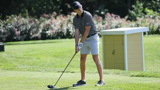 Men's golf player Logan Jaeger getting ready to hit his tee shot as he looks down the fairway
