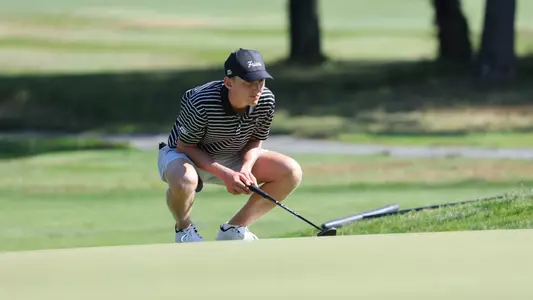 Men's golf player Liam O'Grady reading a putt