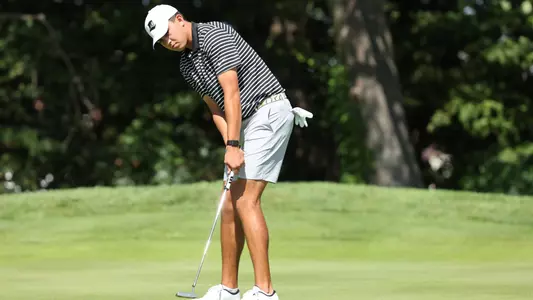 Men's golf player Campbell Skelly hitting a putt on the green
