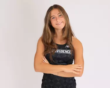Charlotte Cousins crossing her arms while smiling at the camera