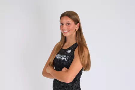 Women's track athlete Morgan Blout poses with arms crossed in uniform for media day