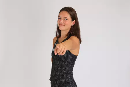 Women's track athlete Lexi Brent pointing at the camera in uniform for media day