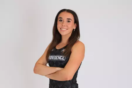 Women's track athlete Emily Bush poses with arms crossed for media day
