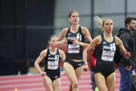 Katie Currie running alongside two others at the Harvard Beantown Challenge