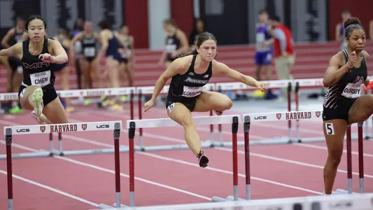 Women's track runner Charlotte Cousins over hurdle