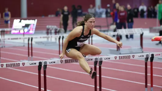Women's track runner Charlotte Cousins over hurdle