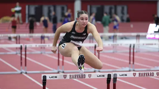 Women's track runner Ella Chandaria over hurdle