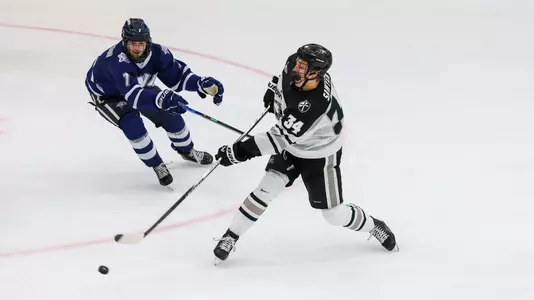 Men's hockey's Logan Sawyer takes a shot against New Hampshire
