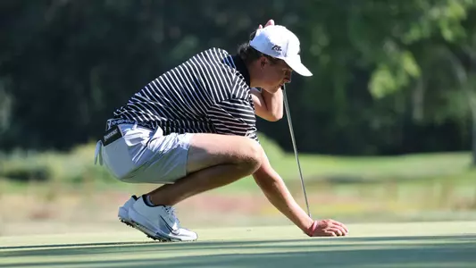 Men's golfer Will Spring putting a ball down to putt