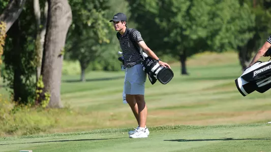 Men's golf player Callan Fahey walking with his bag on the course