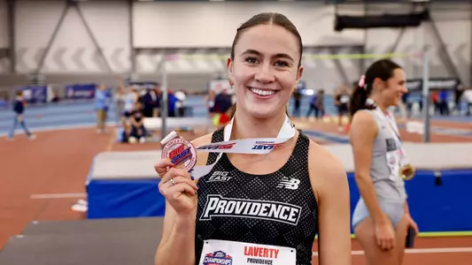 Women's track runner Cara Laverty posing with bronze medal