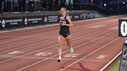 Women's track runner Anna Gardiner winning a race at the Friar Invitational