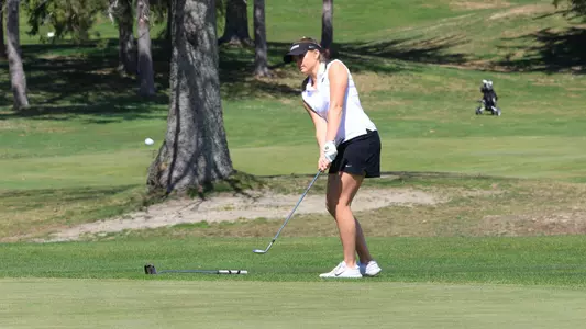 Women's golf player Grace Catalano hitting a chip shot onto the green