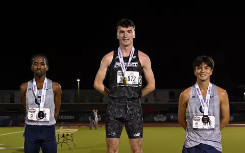 Cormac Dixon on podium after winning the 5000 meter at Big East Championship 