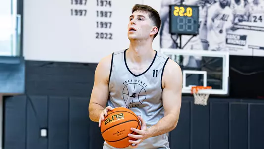 Men's basketball player Ryan Mela sets up for a shot during a practice 