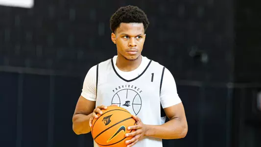 Men's basketball player Gavin Hightower holds a ball in his hands during a practice