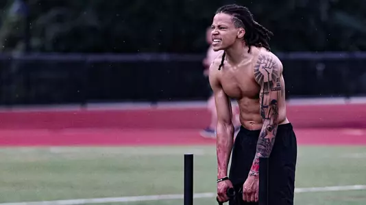 Malik Mack pulling weighted sled in turf workout