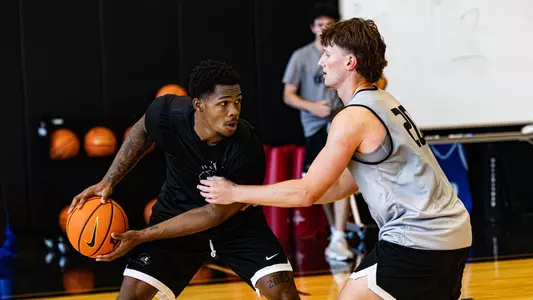 Devin Vanterpool holds basketball while being guarded by teammate Ryan Sabol during practice 